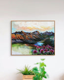 Framed painting of a mountain landscape with flowers on a white wall.