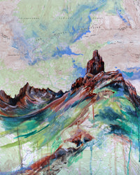 An art print featuring a colorful acrylic painting over a topographic map background, with peaks and a mountain in the foreground.