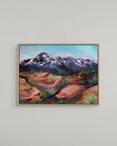 Framed painting of a mountain landscape on a plain wall
