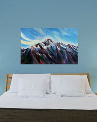 Painting of a mountain on a blue wall above a bed.